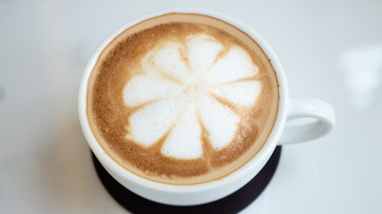 Cappuccino hot coffee cup with milk foam on table in coffee shop