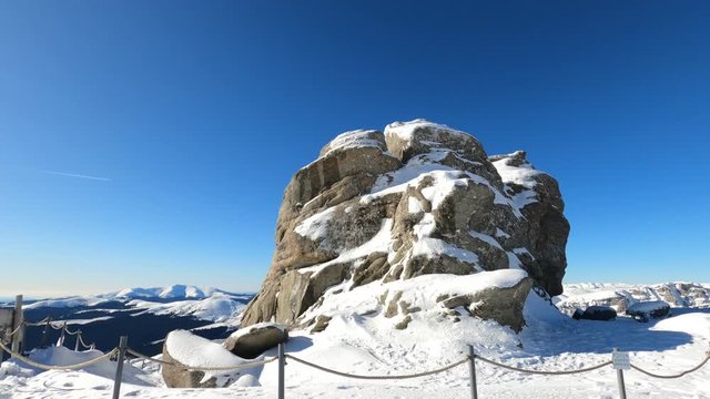 Hyper lapse shot around the sphinx rock formation, sunny, winter day, in the Bucegi Natural Park, southern Carpathians, Romania