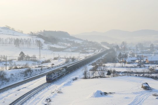 In the winter morning, China railway DF8 and HXN5 trains  pass the village.