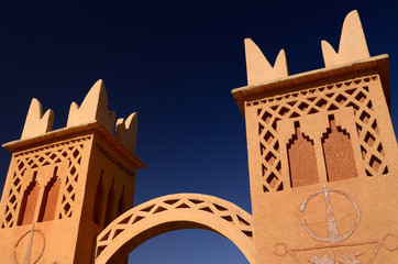 Traditional Berber pise towers made of red adobe and blue sky at resort in Dades Valley