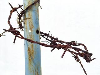 Rusty wires hold on pillar in white background
