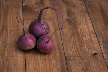 Three beets on a wooden background. New crop.  Harvest season.