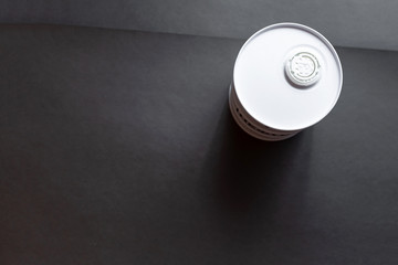 White oil barrel closed with a cork on a dark black background. Flat lay. Copy space.