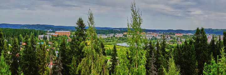 Fototapeta na wymiar Panorama of the city from a height.Panoramic view of the city of Sortavala from a hill in a city park: a forest of conifers, traces of volcanic lava, rocks and volcanic rocks. Russia,Karelia,Sortavala