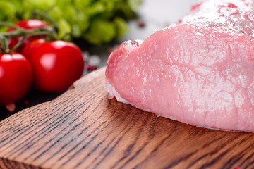 Fresh pieces pork ready to cook on a dark background in the kitchen