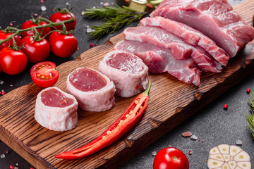 Fresh pieces pork ready to cook on a dark background in the kitchen