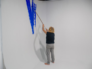 Work: Blonde woman painting chroma key video studio infinite background wall with blue Rosco...