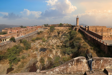 Historic Jaigarh Fort at Jaipur Rajasthan with female tourist enjoying the view at sunset