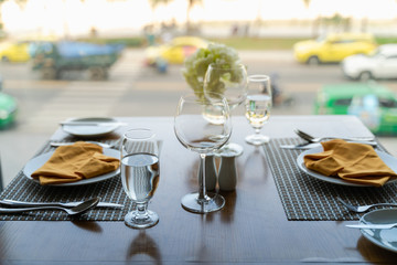 Fresh romantic breakfast table next to morning briliant light window with glasses prepare for the meal