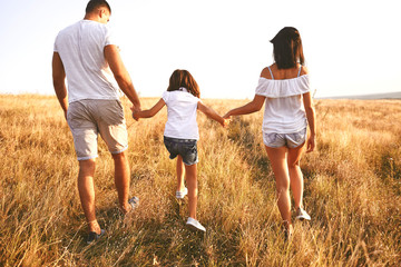 Strolling couple with child in field