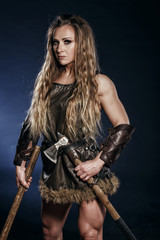 Beautiful female viking woman warrior in battle with big two-handed sword. Ancient times. Amazon fantasy blonde hair sexy girl.