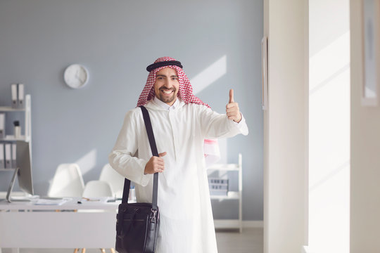 Happy arab man raised his thumb up in a white office