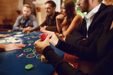 Chips in a gambling player hand at a table in a casino.