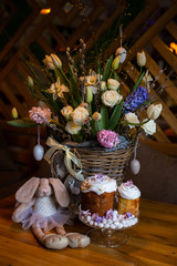 Obraz na płótnie Canvas vertical photo of Easter cakes against a wicker basket with stunning floral decorations