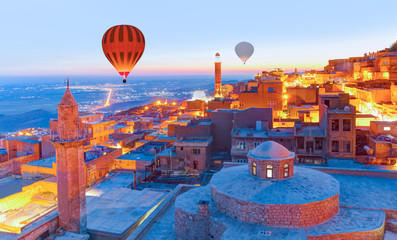 Hot air Balloon flying over Mardin old town - Mardin old town at twilight blue hour - Mardin, Turkey