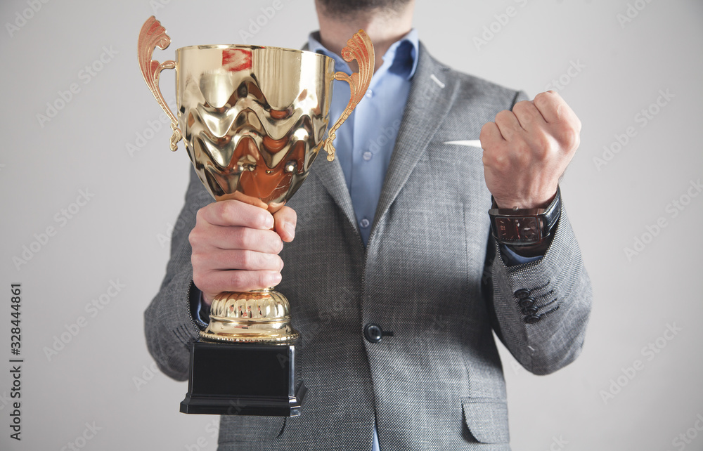 Wall mural Businessman holding golden trophy. Business, Success