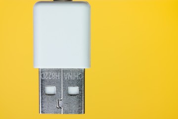 The face of usb cord head like a live robot on a yellow background close up
