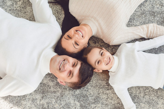 Top view.Happy smiling family hugging while lying on the floor in the room at home. C