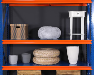 Metal shelving unit with different household stuff on black background