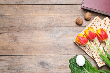 Flat lay composition with symbolic Pesach (Passover Seder) items on wooden table, space for text
