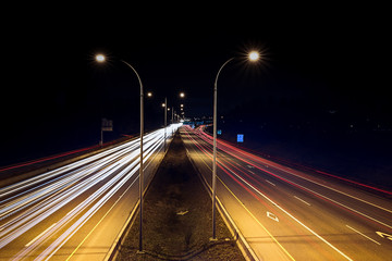 Fototapeta na wymiar Speed traffic - light trails on highway at night. Cars exiting highway