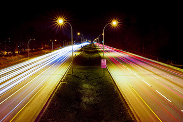 Fototapeta na wymiar Light trails on highway at night. View from pedestrian overpass