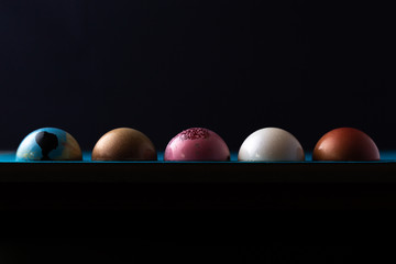 Colorful modern chocolate bonbon truffles on dark with moody lighting