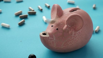 concept of expensive drugs. pills and tablets fall moneybox. slow motion video - Powered by Adobe