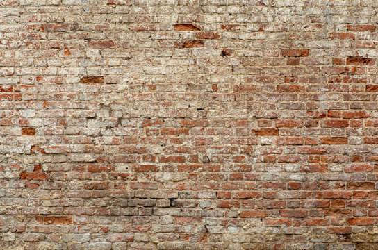 Old brick wall. Brickwork from an old brick in a rustic style. The structure and pattern of the destroyed stone wall. Copy space