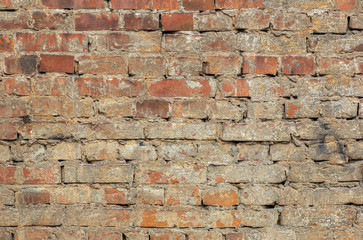 Old brick wall. Brickwork from an old brick in a rustic style. The structure and pattern of the destroyed stone wall. Copy space