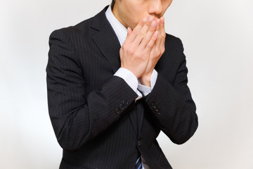 咳をするスーツ姿の男性