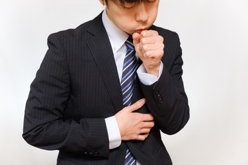 咳をするスーツ姿の男性