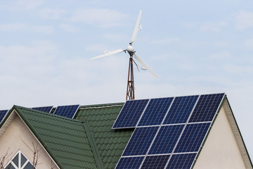 windmill and home with solar panels