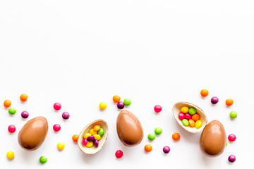 Fototapeta na wymiar Chocolate eggs - Easter symbol - frame on white background top-down copy space