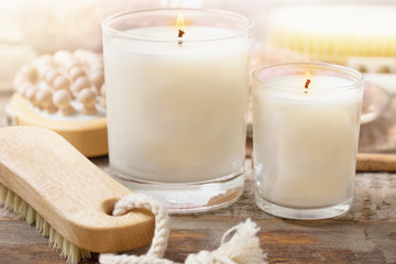 aromatic candles with massagebrush on wooden background close up