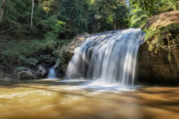 view of silky waterfall flowing on arch rocks around with green forest nature background, Mae Sa Waterfall, Mae Sa Waterfall National Park, Chiang Mai, northern Thailand.