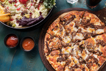 Roast beef pizza with colorful green salad