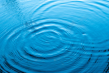 Blue water surface.Top view Closeup blue water rings, Circle reflections in pool.