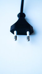 Black electric cable from a table lamp on a white background. Plug for outlet. Energy saving. Conductor of electricity.