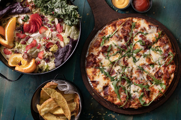 Delicious pizza with salad and fries