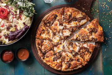 Roast beef pizza with colorful green salad