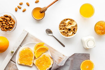 Granola for healthy breakfast. Still life composition with fruits and toast on white background top-down