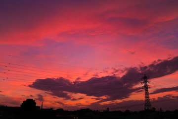 送電塔のシルエットと鮮やかな夕焼け