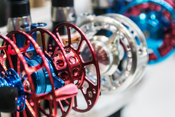 fishing inertial reels of different sizes on the counter in the fishing store. Shallow depth of field