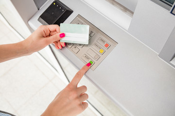 Woman using modern ATM nashine - cash withdrawal.