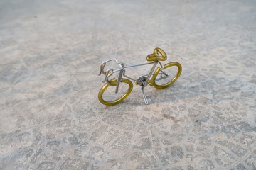 A bicycle which made of  aluminium wire is standing on concreat floor, handicraft model.