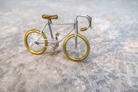 A bicycle which made of  aluminium wire is standing on concreat floor, handicraft model.