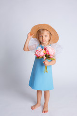 baby girl with a bouquet of flowers and a straw hat on a white background