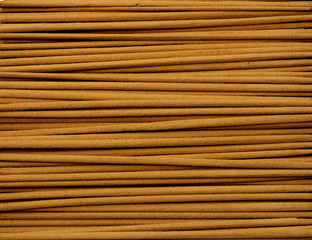 Close up of incense sticks showing brown powder in horizontal direction.
