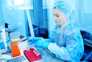 a female scientist makes PCR DNA tests in a modern chemical and bacteriological...